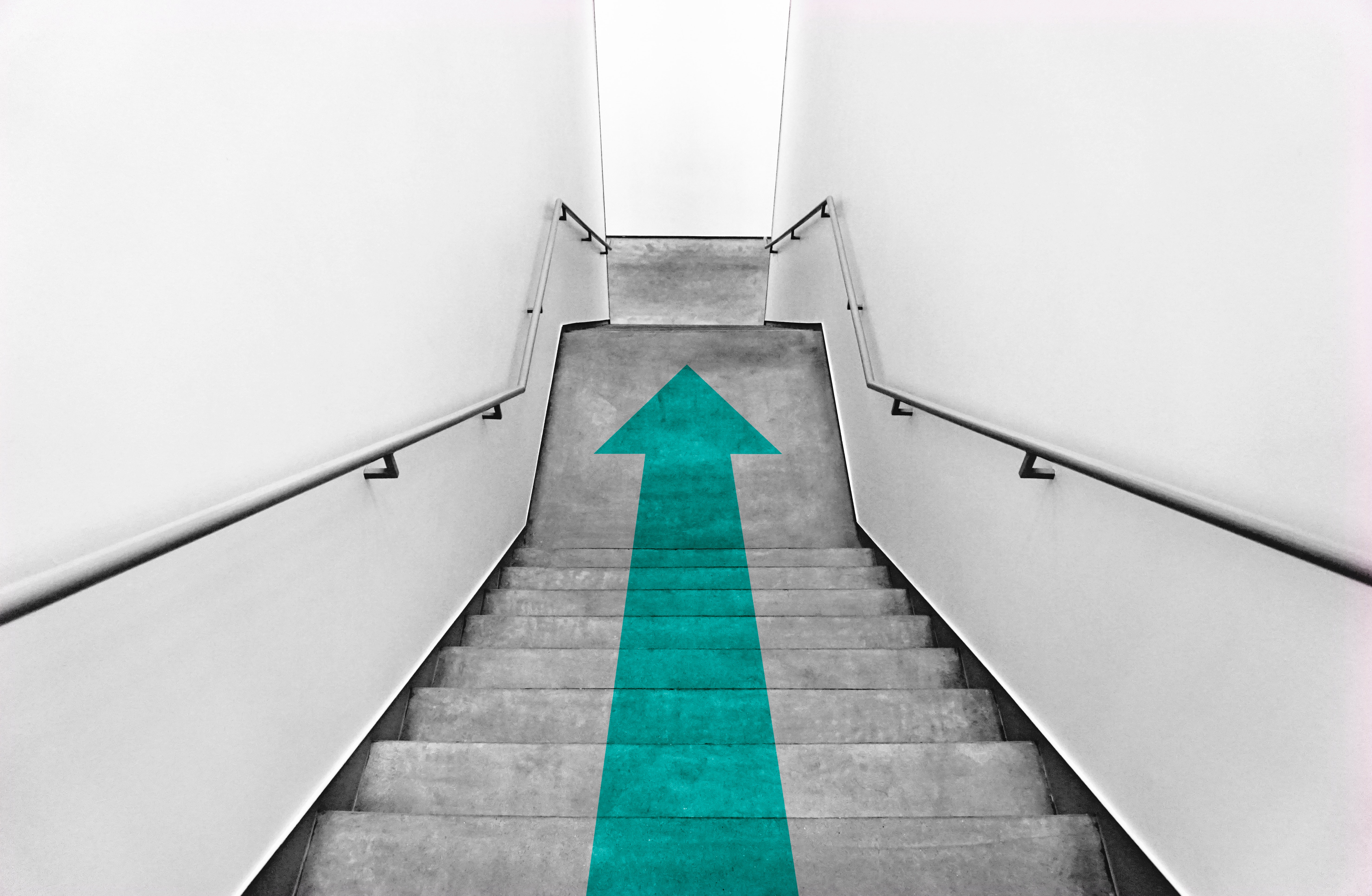 Escaleras de concreto con una flecha verde en medio